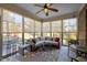 Bright sunroom featuring a wicker sectional sofa, a ceiling fan, and walls of large windows offering views of the yard at 5733 Mizuno Dr, Fuquay Varina, NC 27526
