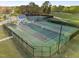 Aerial view featuring tennis courts surrounded by black fencing and verdant greenery at 5733 Mizuno Dr, Fuquay Varina, NC 27526