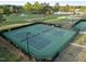 Aerial shot of fenced tennis courts with players in action, adjacent to golf course and lake at 5733 Mizuno Dr, Fuquay Varina, NC 27526