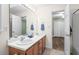 Bathroom with double sinks, a large mirror, and an adjoining room with hardwood floors at 5911 Mountain Island Dr, Durham, NC 27713