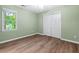 Bright bedroom with two double closets, hardwood floors, and a large window at 5911 Mountain Island Dr, Durham, NC 27713