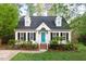 Charming two-story home featuring a manicured lawn, black shutters, and a welcoming turquoise front door at 5911 Mountain Island Dr, Durham, NC 27713