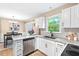 Bright kitchen featuring white cabinets, granite countertops, and stainless steel appliances at 5911 Mountain Island Dr, Durham, NC 27713