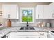 Close-up of updated kitchen featuring granite countertops and bright white cabinets at 5911 Mountain Island Dr, Durham, NC 27713