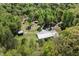 Aerial view showcases the house, multiple sheds, and surrounding trees and land at 605 Faucette Mill Rd, Hillsborough, NC 27278