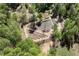 High aerial shot of a mulched and planted garden with a shed surrounded by woods at 605 Faucette Mill Rd, Hillsborough, NC 27278