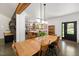 Spacious dining area flowing into a bright kitchen with an oversized wooden table and chairs at 605 Faucette Mill Rd, Hillsborough, NC 27278