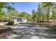 Backyard building with gravel driveway surrounded by lush trees providing private retreat with ample parking at 605 Faucette Mill Rd, Hillsborough, NC 27278