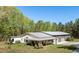 Beautiful exterior featuring white siding, metal roof, covered porch with swing, and an attached garage at 605 Faucette Mill Rd, Hillsborough, NC 27278