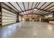 Spacious garage featuring a high ceiling, open layout, concrete floor, and large roll-up door, perfect for storage and projects at 605 Faucette Mill Rd, Hillsborough, NC 27278