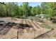 Elevated view of a large garden with rows of planted beds, plus a barn and shed at 605 Faucette Mill Rd, Hillsborough, NC 27278