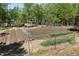 An enclosed garden featuring neat rows of plants and irrigation setup at 605 Faucette Mill Rd, Hillsborough, NC 27278