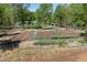 Wide-angle shot of an enclosed garden with plants, featuring a shed and barn at 605 Faucette Mill Rd, Hillsborough, NC 27278