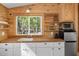 Compact kitchen featuring bright white cabinetry, butcher block countertops, and built-in shelving, maximizing space and functionality at 605 Faucette Mill Rd, Hillsborough, NC 27278