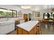 Kitchen island with marble top, open shelving, stainless appliances, and seating at 605 Faucette Mill Rd, Hillsborough, NC 27278