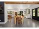 Open-concept living space with exposed beam, wooden dining table and view into modern kitchen at 605 Faucette Mill Rd, Hillsborough, NC 27278