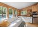 Cozy living room with wood paneled walls and natural light, adjacent to a mini-kitchen, creating a comfortable living space at 605 Faucette Mill Rd, Hillsborough, NC 27278