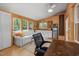 Bright living room with wood walls, white sofa, many windows, and built-in shelving at 605 Faucette Mill Rd, Hillsborough, NC 27278