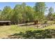 Spacious yard with mature trees, garden plot, and outbuilding at 605 Faucette Mill Rd, Hillsborough, NC 27278