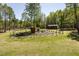 Large yard with mature trees, garden plot, and outbuildings at 605 Faucette Mill Rd, Hillsborough, NC 27278