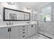 Elegant bathroom featuring double vanity, marble tile, and a glass-enclosed shower for a spa-like experience at 608 Derby Ct, Durham, NC 27707