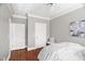 Spacious bedroom with neutral color palette, two entry doors and a bench at 608 Derby Ct, Durham, NC 27707