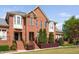 Elegant brick townhouse showcases lush landscaping and classic architectural details at 608 Derby Ct, Durham, NC 27707