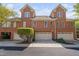 Symmetrical brick townhouse exteriors with multiple garage doors, neat landscaping, and classic architectural details at 608 Derby Ct, Durham, NC 27707