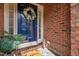 Close-up of a charming blue front door adorned with a wreath, welcoming guests at 608 Derby Ct, Durham, NC 27707