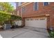 Townhouse exterior featuring a two-car garage with a brick facade and well-maintained landscaping at 608 Derby Ct, Durham, NC 27707