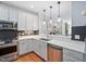 Bright kitchen showcasing stainless steel appliances, white cabinets, and seamless flow to living spaces at 608 Derby Ct, Durham, NC 27707