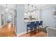 Modern kitchen features sleek white cabinetry, stylish lighting, and a convenient breakfast bar with seating at 608 Derby Ct, Durham, NC 27707