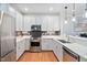 Well-equipped kitchen boasts stainless steel appliances, ample counter space, and elegant white cabinets at 608 Derby Ct, Durham, NC 27707
