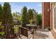 Outdoor patio with a table, chairs, red brick house, and scenic backyard at 608 Derby Ct, Durham, NC 27707
