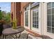 Outdoor patio table and chairs with brick exterior and glass doors at 608 Derby Ct, Durham, NC 27707