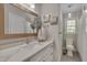Elegant bathroom featuring quartz counters, gold accents, and a decorative mirror, plus a window at 6105 Bellow St, Raleigh, NC 27609