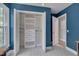 Open closet with custom shelving and drawers offering ample storage space in a vibrant blue bedroom at 6105 Bellow St, Raleigh, NC 27609