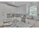 The updated kitchen features white cabinets, granite counters, and a herringbone backsplash at 6105 Bellow St, Raleigh, NC 27609