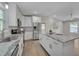 Kitchen with granite counters, stainless appliances, herringbone backsplash, island, and hardwoods at 6105 Bellow St, Raleigh, NC 27609