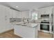 A modern kitchen with white cabinets, granite countertops, and stainless steel appliances at 6105 Bellow St, Raleigh, NC 27609