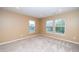 Sunlit bedroom with three windows and neutral carpeting at 617 Conover Rd, Durham, NC 27703