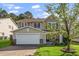 Inviting two-story home with a two-car garage, manicured lawn, and lovely landscaping on a sunny day at 617 Conover Rd, Durham, NC 27703