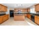 Kitchen featuring an island, ample counter space, wood cabinets, and modern appliances at 617 Conover Rd, Durham, NC 27703