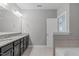 Bathroom showcasing double sinks with granite countertop, large mirror, and soaking tub at 633 Democracy St, Raleigh, NC 27603