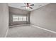 Spacious bedroom with a ceiling fan, plush carpeting, and a large window for natural light at 633 Democracy St, Raleigh, NC 27603