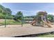 Community playground with swings, slides, and picnic area against a wooded backdrop at 633 Democracy St, Raleigh, NC 27603
