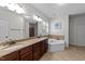 Bathroom features a double sink vanity with granite countertops and a separate soaking tub at 64 Thousand Oaks Ct, Clayton, NC 27527