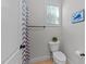 Bathroom featuring a toilet, small window, a light gray shower curtain, and towel rack at 64 Thousand Oaks Ct, Clayton, NC 27527