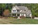 Charming two-story home with stone accents, lush landscaping, and inviting front porch at 64 Thousand Oaks Ct, Clayton, NC 27527