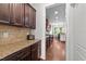Hallway view of kitchen featuring granite counters and stainless appliances at 64 Thousand Oaks Ct, Clayton, NC 27527